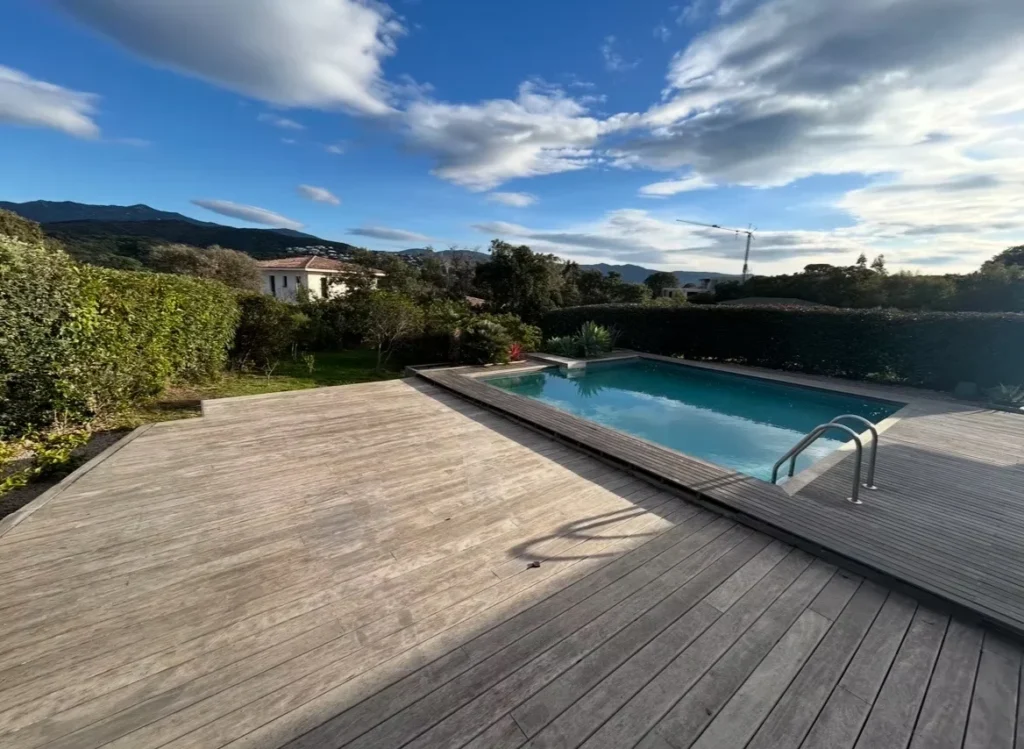 Piscine rénovée avec plage en bois
