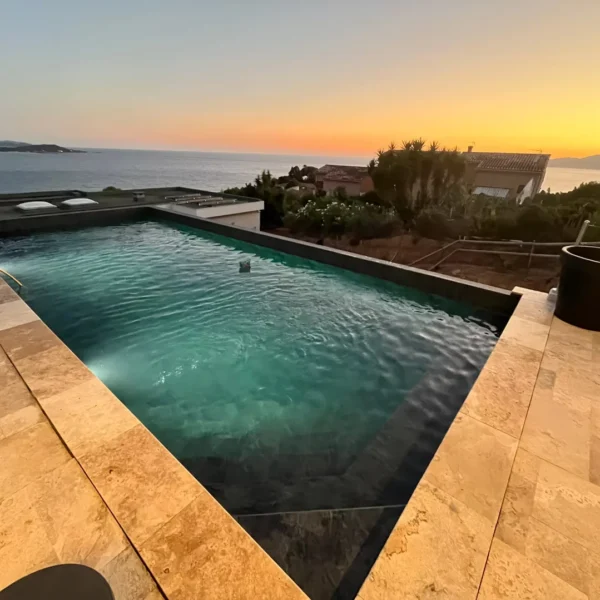Piscine au coucher du soleil avec vue sur la mer